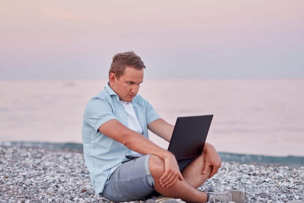 Man Working With Laptop On The Beach Near The Sea 2022 05 19 07 17 02 Utc 1024x683