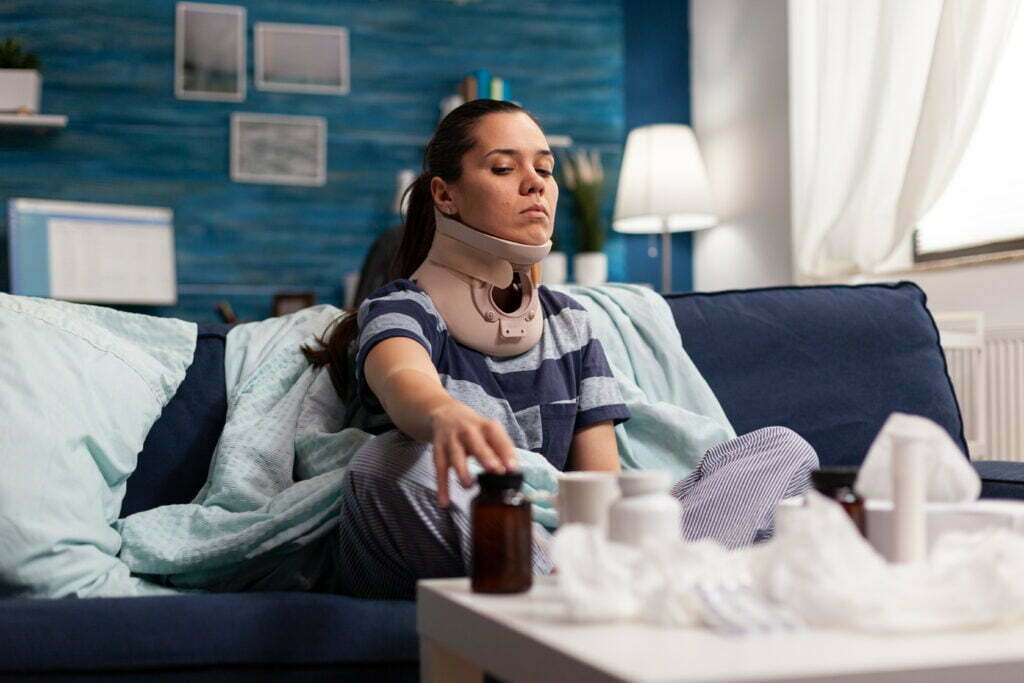 Temporary Total Disability vs. Temporary Partial Disability Woman With Cervical Neck Collar Sitting On Sofa 2021 09 17 16 32 40 Utc 1024x683