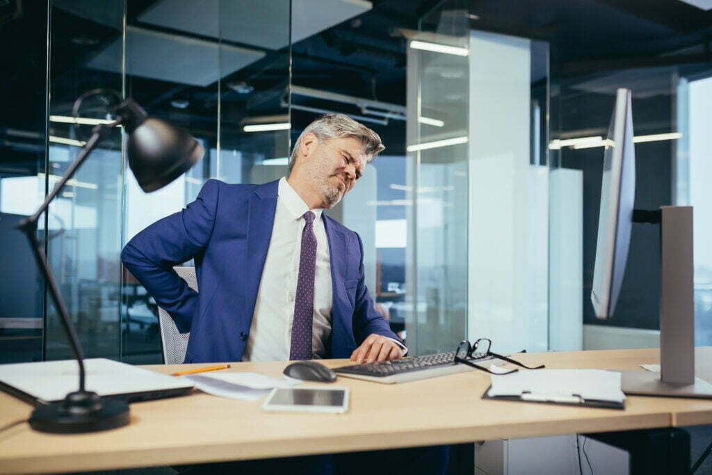 A Shift in the World of Workers Compensation 48126062 Tired Worker Businessman Working In The Office Sitting At The Computer The Man Has Severe Back Pain 1024x683
