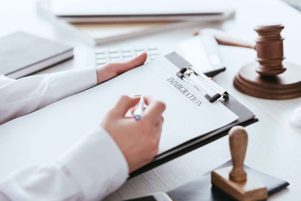 What Should You Do in an Immigration Emergency? Cropped View Of Woman Holding Pen Near Document Wi 2022 12 16 19 42 13 Utc 1024x683