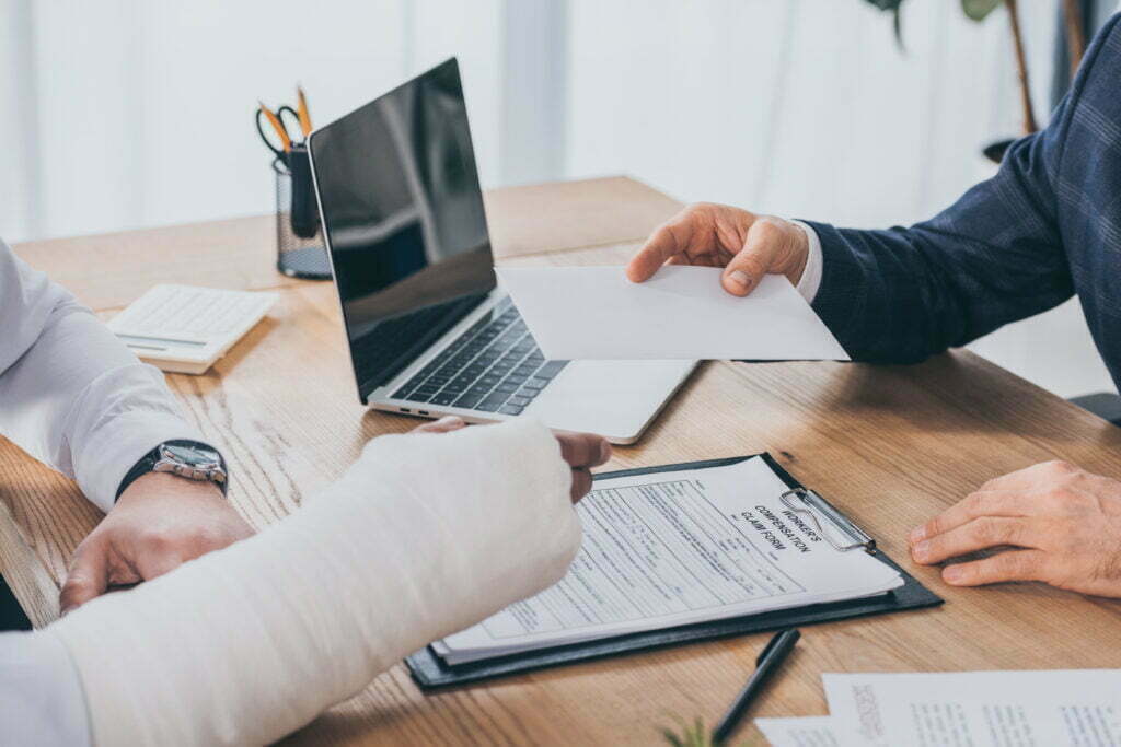 Taking the First Steps in a Workers' Comp Claim: Taking Legal Action Cropped View Of Businessman Sitting At Table And G 2022 12 16 20 50 40 Utc 1024x683