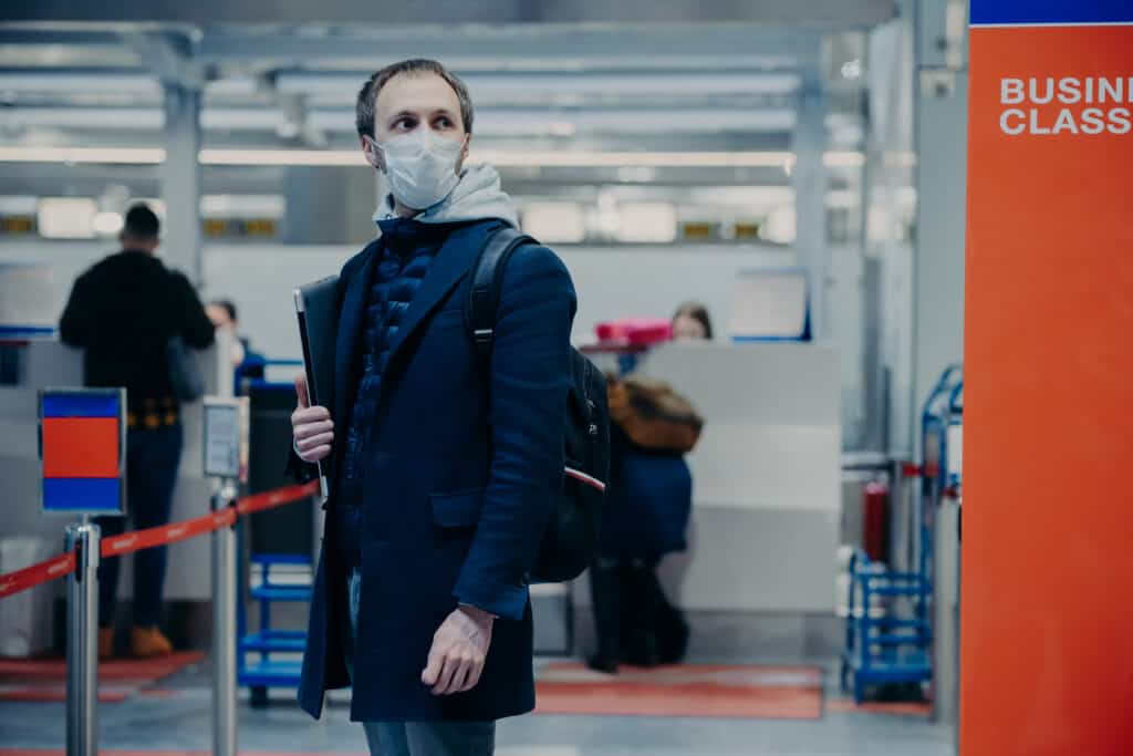 Can an Adjuster Make You to Travel for Medical Appointments? Man With Luggage Wears Medical Protection Mask P 2022 03 30 00 24 26 Utc 1024x683