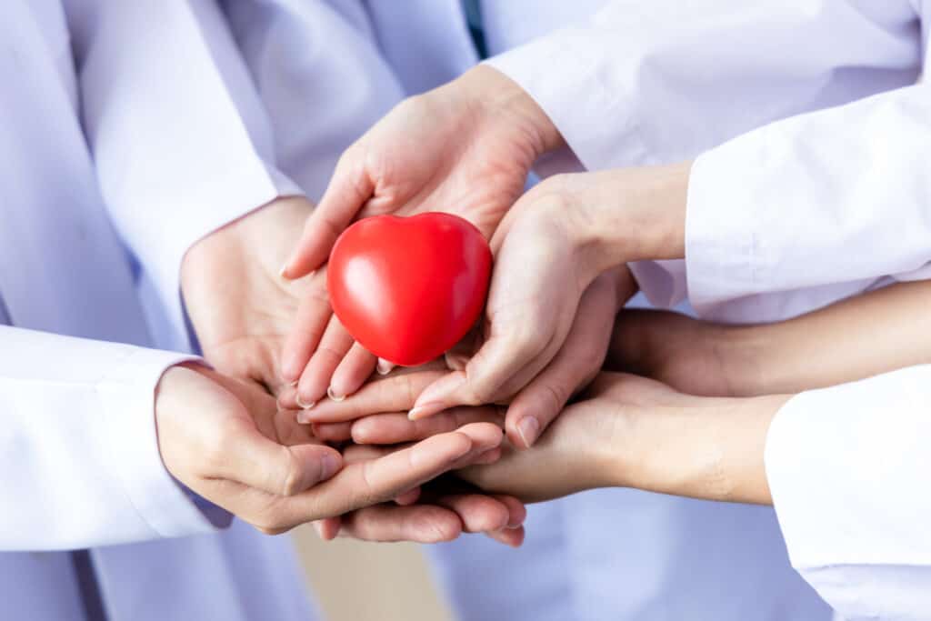 Should You File Your Claim on Your Health Insurance Because Your Employer Told You to? Group Of Hands Holding A Red Heart Hand Of Doctor 2022 09 28 22 47 53 Utc 1024x683